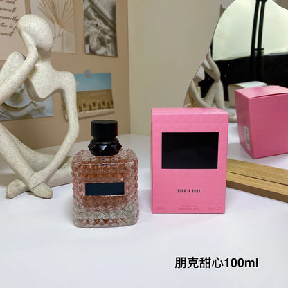 Valentino Perfume bottle and pink box on a table with decorative items in the background