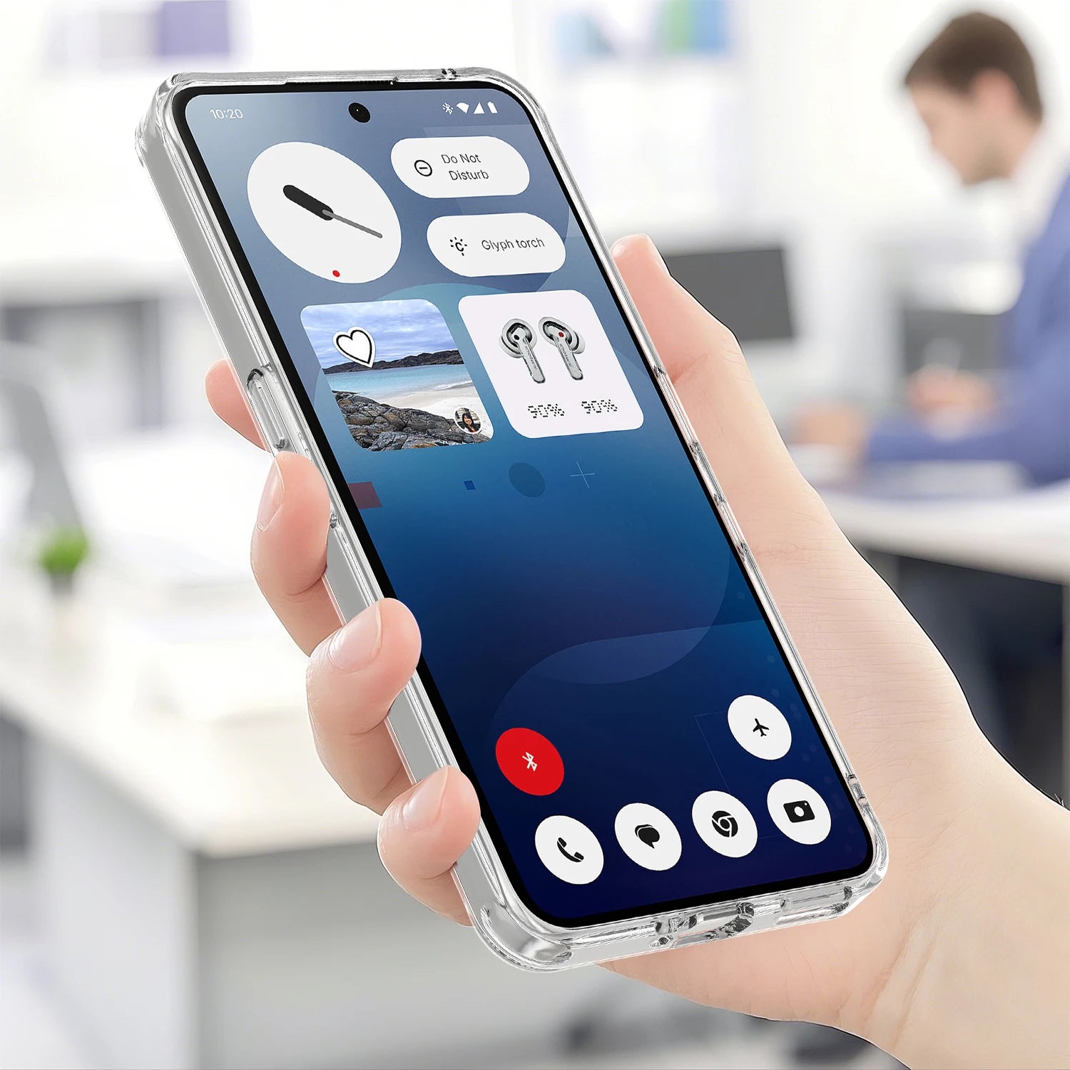 Hand holding a smartphone with a call interface displayed, blurred office background