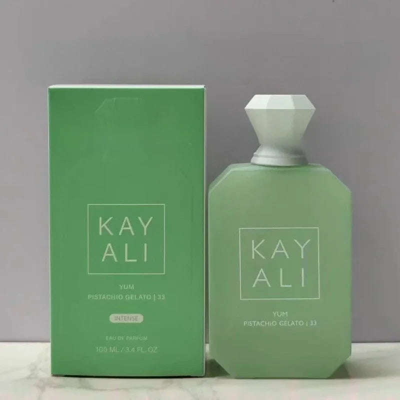 Green perfume bottle and packaging with 'KAY ALI' branding on a gray background