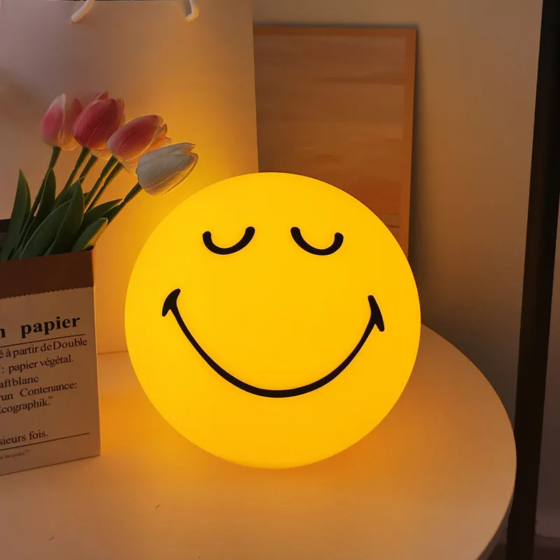 Smiley face night light on a surface with tulips in the background
