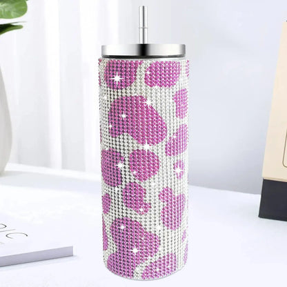 Tumbler with pink leopard print and rhinestone details on a white surface.