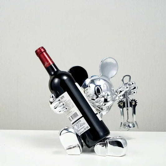 Silver wine bottle holder with a red wine bottle on a light gray background