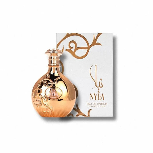 Rose gold perfume bottle with decorative design next to its packaging on a white background