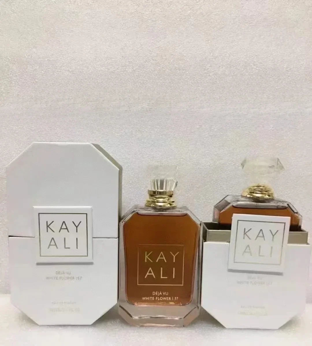 Two bottles of Kay Ali perfume with packaging on a light background