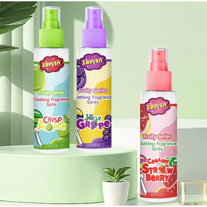 Three Ebyven fruit-themed clothing fragrance sprays on a light green background