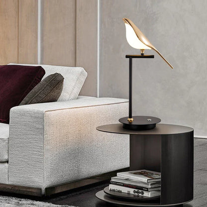 Modern living room with a gray sofa, black side table, and decorative lamp.