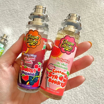 Two 'Chupa Chups' body mist bottles held in a hand against a neutral background