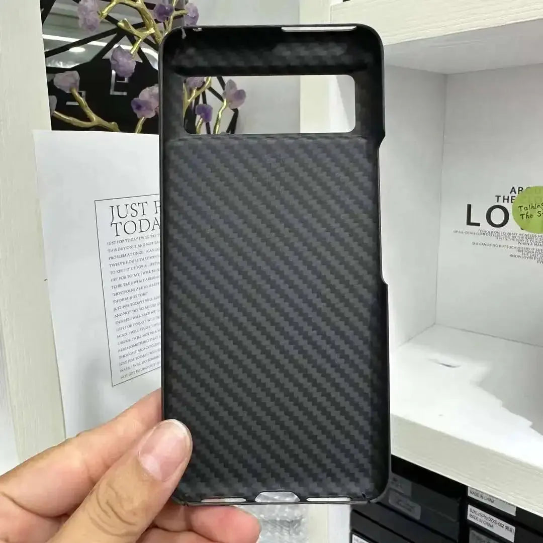 Carbon fiber patterned phone case held by a hand with a blurred background