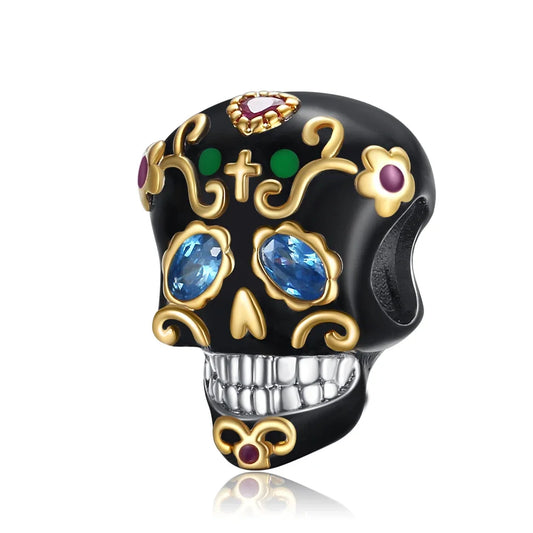 Decorative skull charm with gemstones on a white background