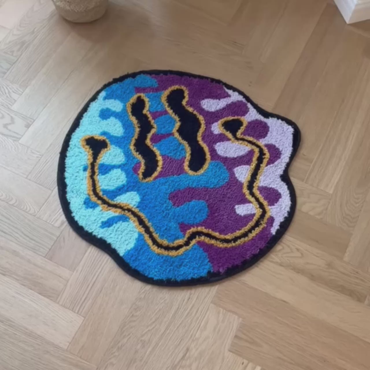 video of a technicoloured smiley face rug