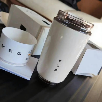 White tumbler with 'SMEG' branding on a dark surface